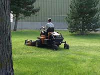 A groundskeeper mowing with a maintenance-reliable asset