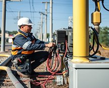 A utility worker conducts preventive maintenance in the field.