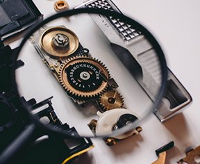 Image: magnifying glass over gears