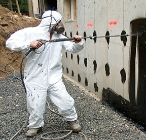 Image: man in hazmat suit working on wall
