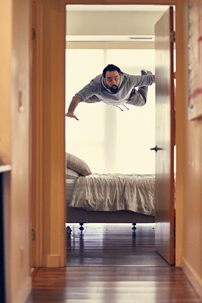 Image: man bouncing off bed