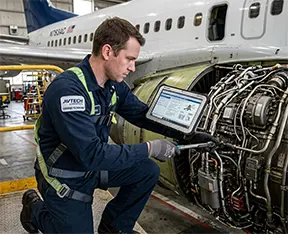 A mechanic workiing on a plane using a CMS work order.