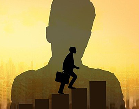 Image: silhouette of man walking up a flight of buildings