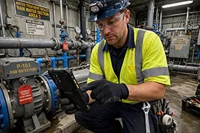 A maintenance tech uses a CMMS work order for water treatment inspections.
