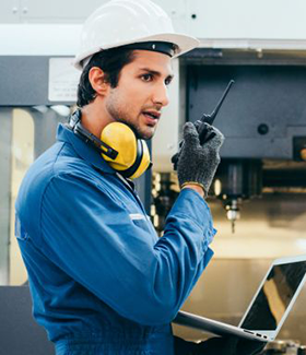 Image: worker using laptop and walkie-talkie