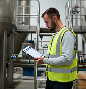 A technician uses an AI-enhanced CMMS for energy-efficient asset management.