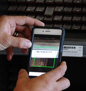 Image: hand holding barcode scanner