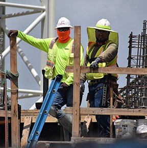 Image: 2 construction workers on a deck