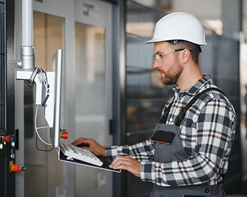 A technician uses a CMMS for industrial preventive maintenance.