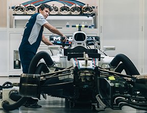 Image: man working on a race car engine