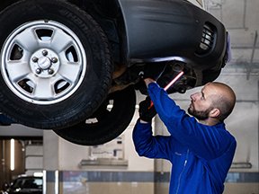 Image: man working under car